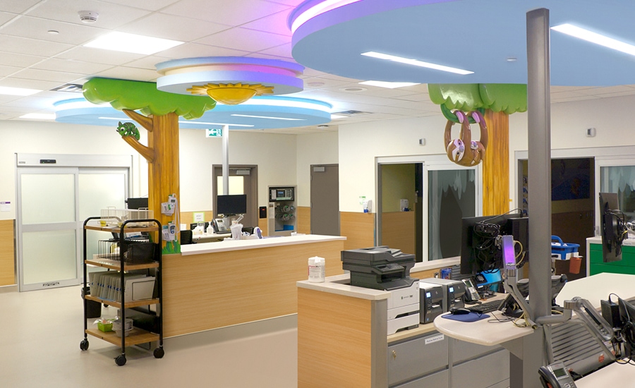 Custom sculpted trees with sloth and chameleon characters in a hospital ER department