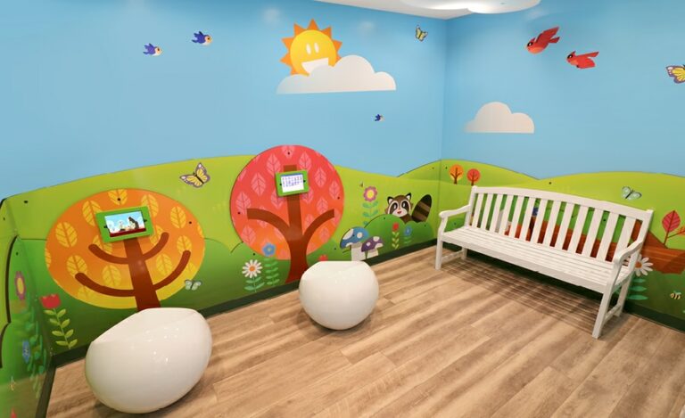Contemporary kid's park-themed wall murals for a kid's playroom with wall mounted gaming pads.