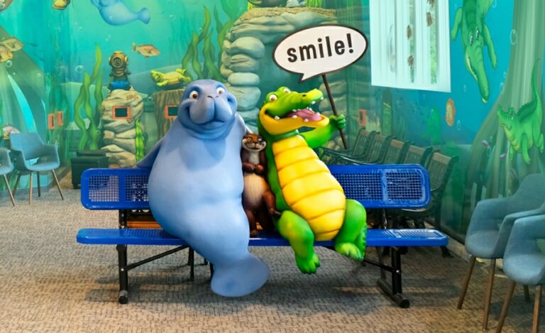 Photo-op bench in kid's dental office featuring crocodile, manatee, and otter characters.