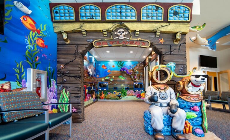 Underwater-themed play area with colorful wall murals, sculpted sea-themed characters and shipwreck cladding.