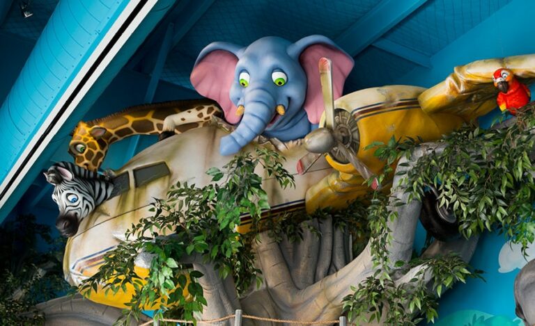 Large, sculpted jungle characters in a crashed plane stuck in a tree.