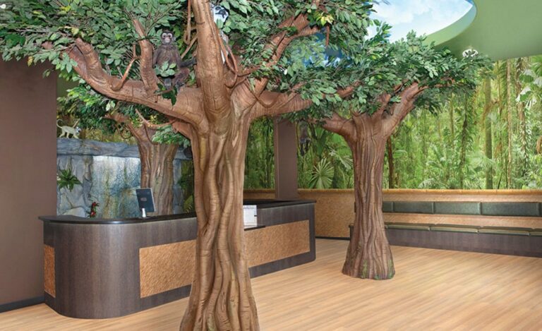 Realistic jungle-themed reception area with 2 sculpted floor-to-ceiling trees and a monkey sitting in the leafy branch