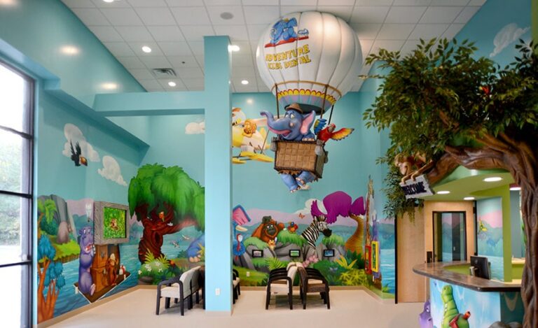 Playful jungle-themed dental office with wall murals, 3D clad reception desk and view of a large hot air balloon sculpture hanging from the ceiling. A comical viewpoint shows an elephant bursting through the bottom of the basket
