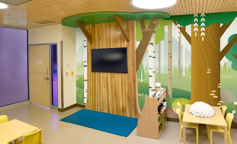 Woodland-themed mural with 3D cutout tree in a daycare room