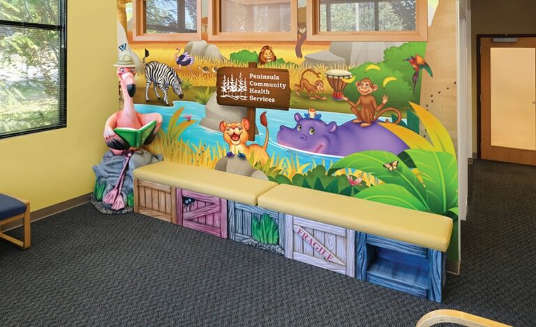 Colorful wooden crate bench with photo op sculpted flamingo character against a colorful safari-themed wall mural