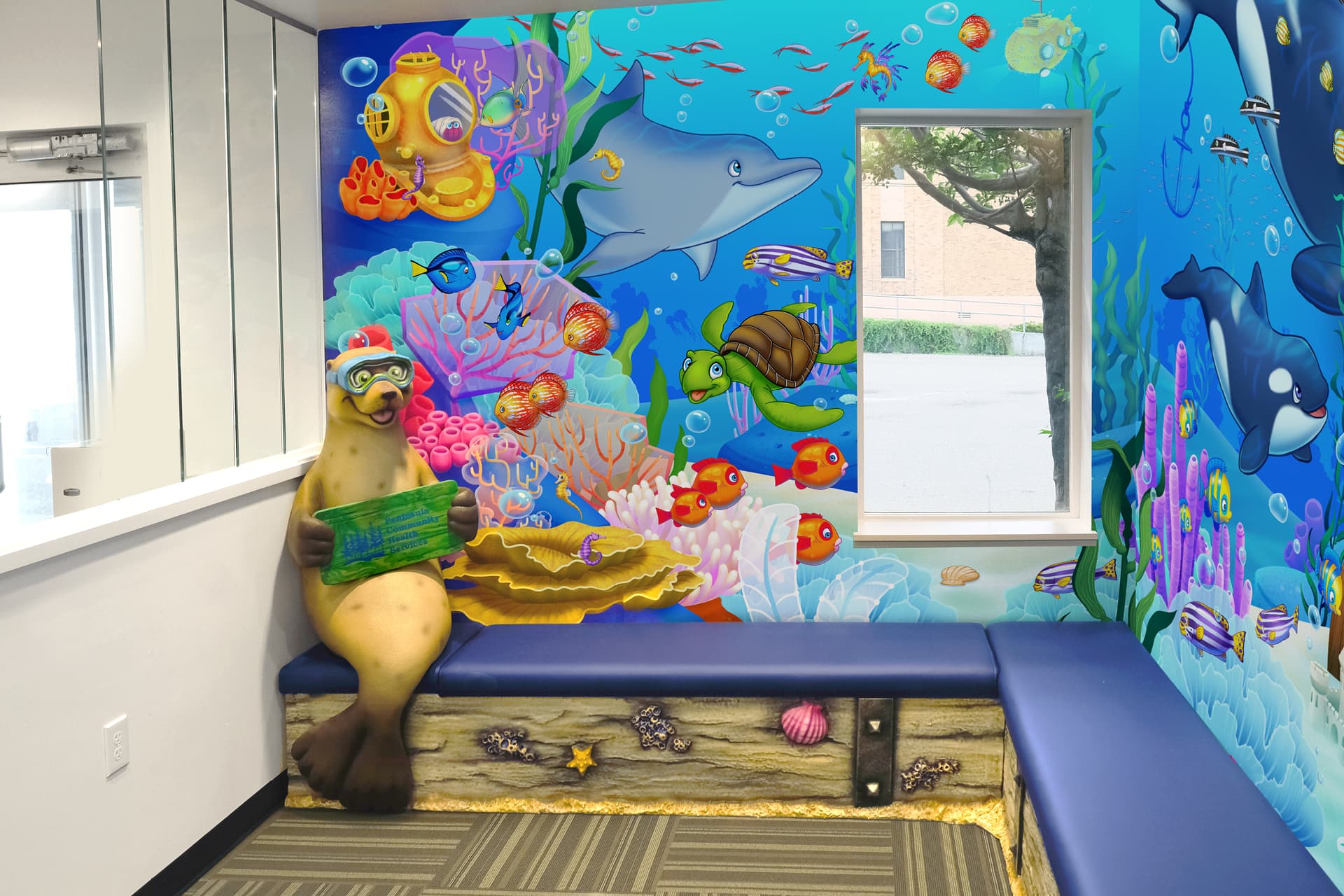 A colorful underwater-themed waiting room showcases a vibrant children’s decor. A playful seal statue with goggles and a map sits on a blue bench next to a window, surrounded by coral, fish, dolphins, and turtles.