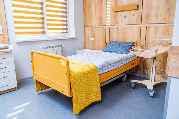 Modern hospital room with a yellow framed bed.