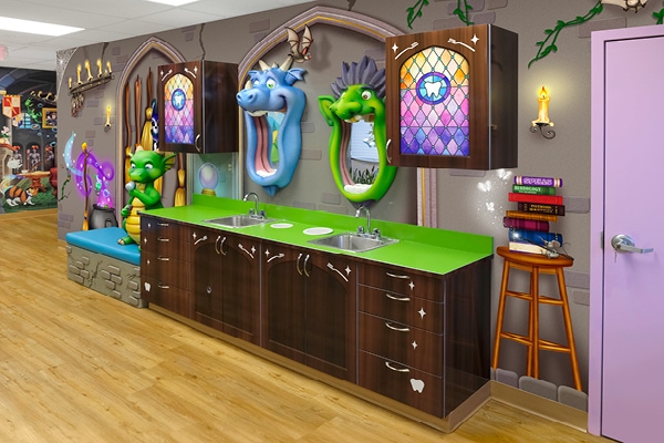 A whimsical dentist office with colorful dragon and cat wall decorations, green countertops with sinks, wooden cabinets, and playful medieval-themed artwork showcases a stunning transformation in children's decor, creating a fun and inviting atmosphere for kids.
