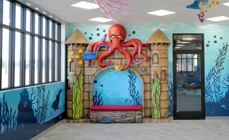 Cladded bench with a surrounding sandcastle themed structure and an overhanging red octopus
