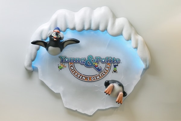 Iceberg themed sign decorated with penguins and reads "Young & Polite Children's Dentistry".