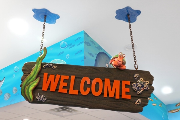 Plank themed welcome sign a little crab perched on top.