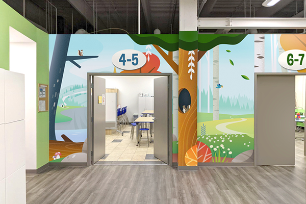 Colorful classroom hallway with cartoon forest-themed wall art and children’s ministry signs for age groups “4-5” and “6-7.” Open double doors reveal a Sunday school classroom with tables, blue chairs, and gray wood flooring.
