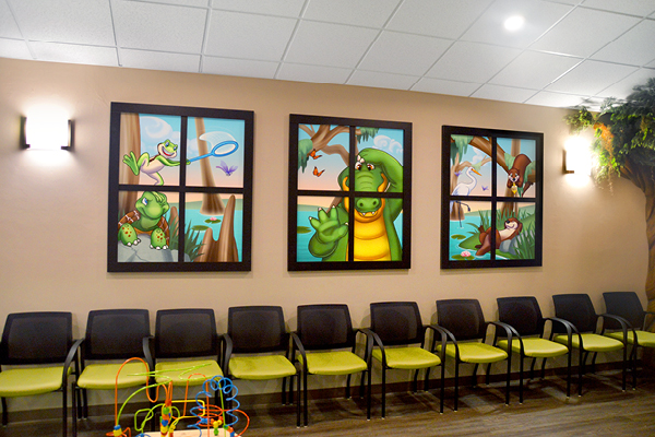 A waiting room with three framed wall murals featuring cartoon alligators and swamp animals in a playful, nature-themed setting.