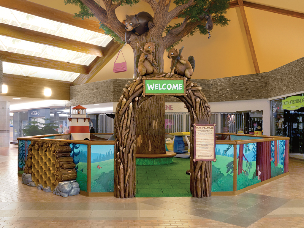 Experience a themed environment transformation in this indoor play area—designed like a treehouse with cartoon squirrels, raccoons, forest panels, and benches—for the perfect before and after adventure inside the shopping mall.