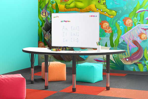 A colorful speech therapy room with a whiteboard showing vowel sounds, a curved table, bright cube seats, and a wall mural featuring underwater animals like fish, an alligator, and sea plants.