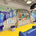 A room with a wall mural and a whale creates a creative space, perfect for brainstorming or even hiring interviews.